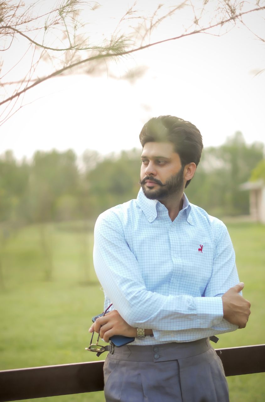 Man standing outdoors with a blurred natural background