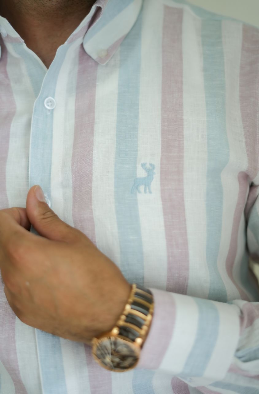 Close-up of a person wearing a striped shirt with a small logo of luxento