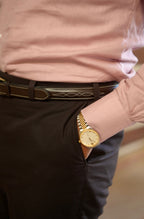 Person wearing a gold watch with a blurred background